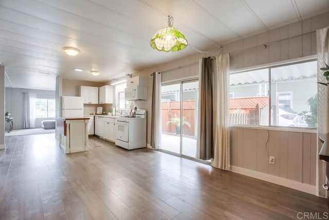 a kitchen with stainless steel appliances kitchen island wooden floors and white cabinets