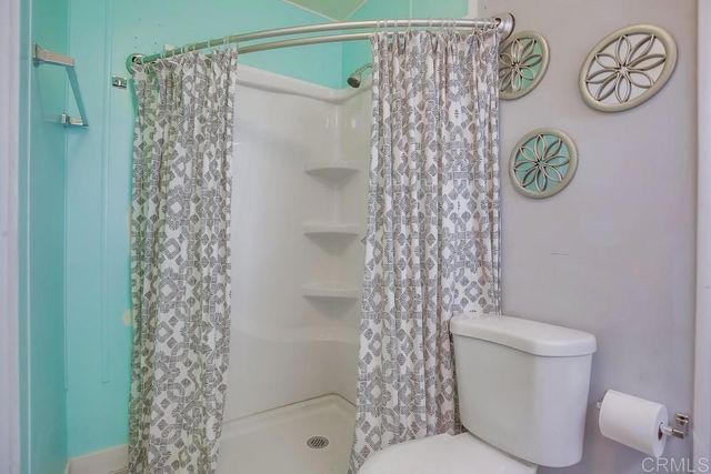 a bathroom with a shower curtain and a toilet