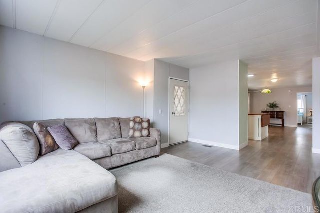 a living room with furniture and a view of kitchen