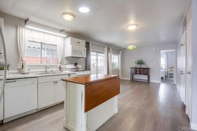 a large kitchen with stainless steel appliances granite countertop a lot of counter space and wooden floors