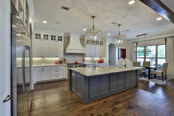 a large kitchen with kitchen island a island a sink stainless steel appliances and cabinets