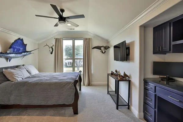a bedroom with a bed and a flat tv screen on the dresser