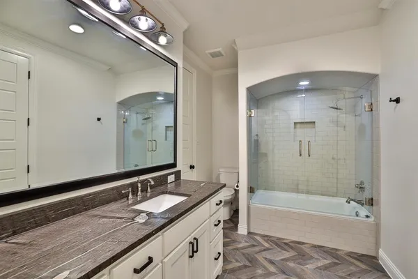 a bathroom with a granite countertop sink mirror and bathtub