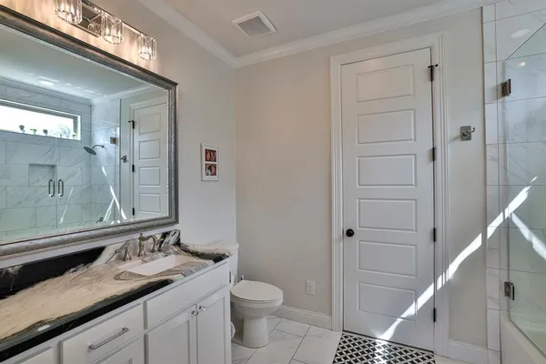 a bathroom with a granite countertop sink toilet and shower