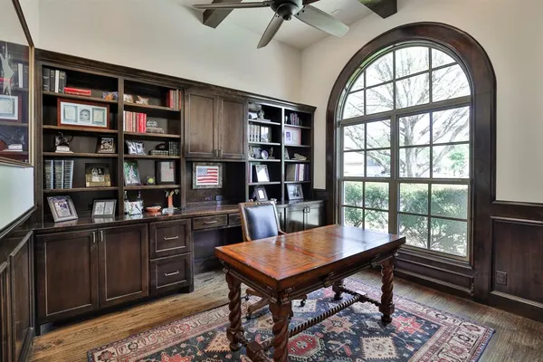 a view of a workspace with furniture bookshelf and a window