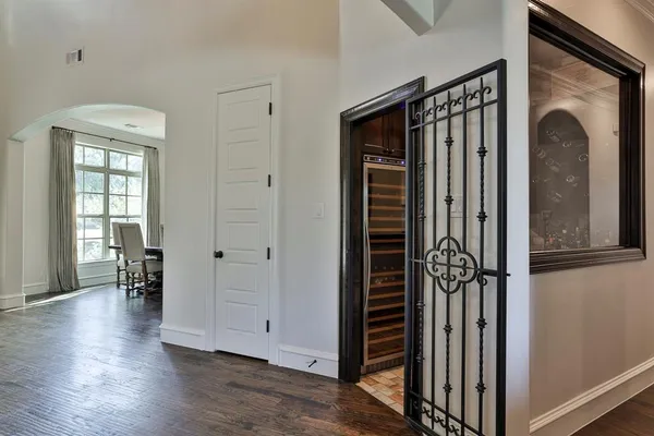 a view of a hallway with wooden floor and a livingroom