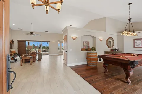 a living room with furniture a dining table wooden floor and a fireplace