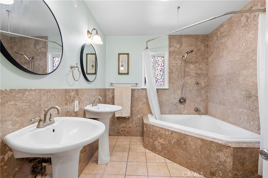 3388 Ramona Road Atascadero, CA 93422 - Photo 23 of 55 The main bathroom has been upgraded and features dual pedestal sinks and tiled walls.