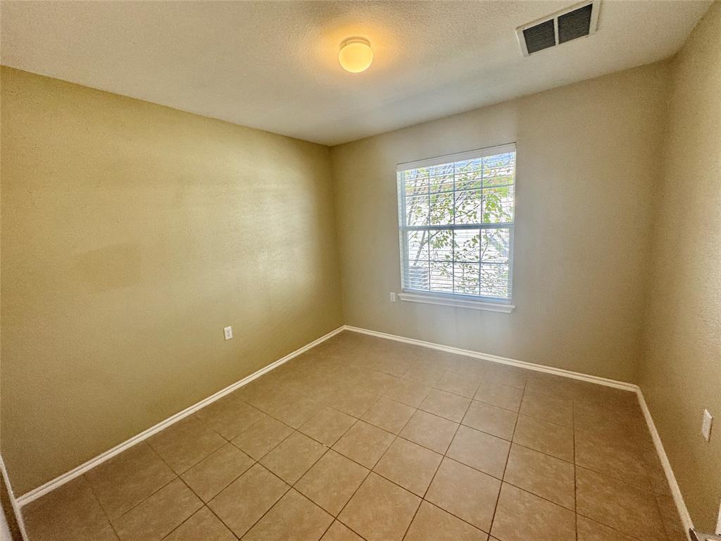 7812 Duber Lane Austin, TX 78747 - Photo 13 of 15 Neutral-toned room featuring a single window with blinds, tile flooring, and a ceiling-mounted light fixture