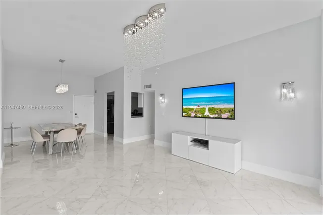 a view of an empty room with wooden floor and a flat screen tv