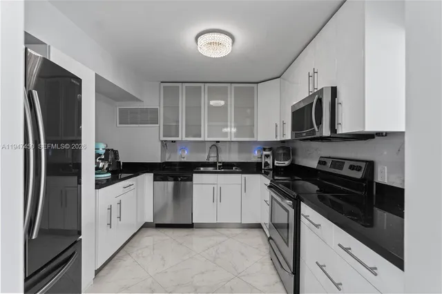 a kitchen with stainless steel appliances granite countertop a refrigerator a stove and a sink