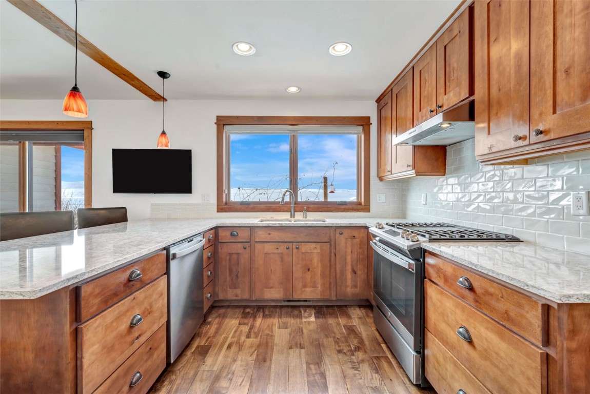 870 Dry Creek Road Hayden, CO 81639 - Photo 9 of 50 a kitchen with stainless steel appliances granite countertop a stove and a sink