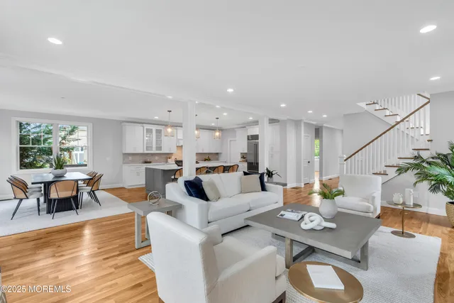 a living room with furniture kitchen view and a wooden floor