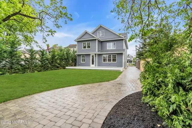 a view of a house with a yard and potted plants