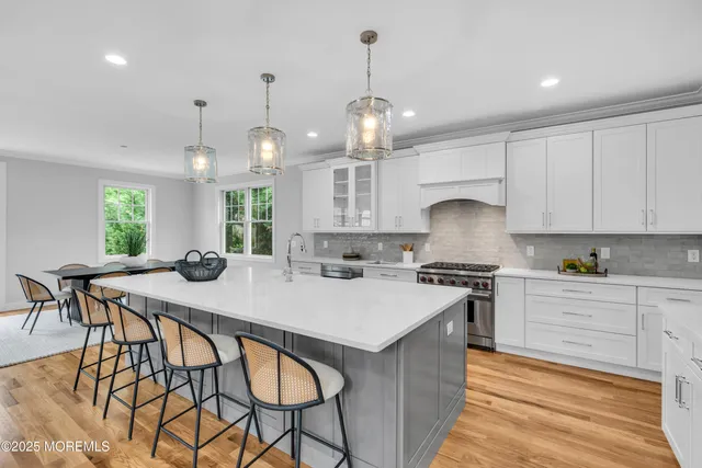a kitchen with stainless steel appliances granite countertop a kitchen island a stove a table and chairs in it