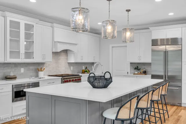 a kitchen with stainless steel appliances a table chairs and cabinets