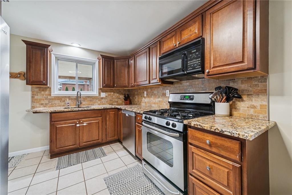 1000 Colfax Street Springdale, PA 15144 - Photo 5 of 25 a kitchen with stainless steel appliances granite countertop a stove sink microwave and cabinets