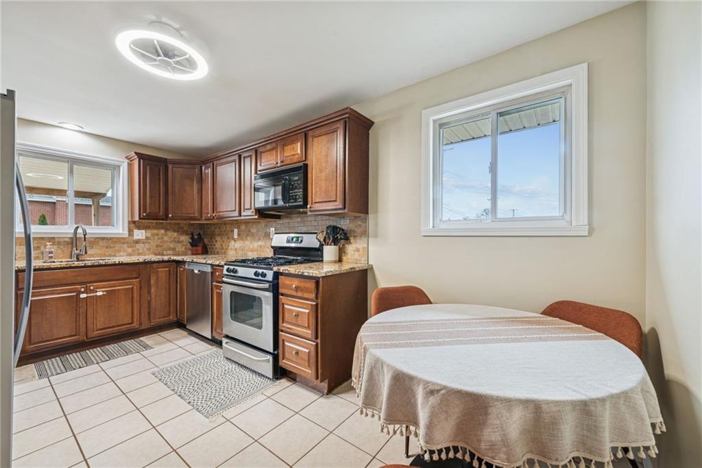 1000 Colfax Street Springdale, PA 15144 - Photo 9 of 25 a kitchen with stainless steel appliances granite countertop a stove a sink and a microwave