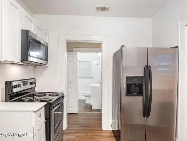 a kitchen with stainless steel appliances granite countertop a refrigerator and a stove top oven