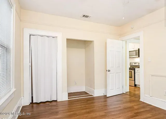 a view of a room with wooden floor