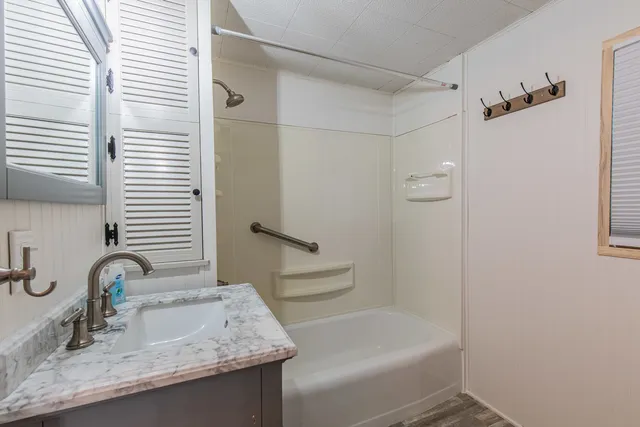 a bathroom with a granite countertop sink toilet and shower