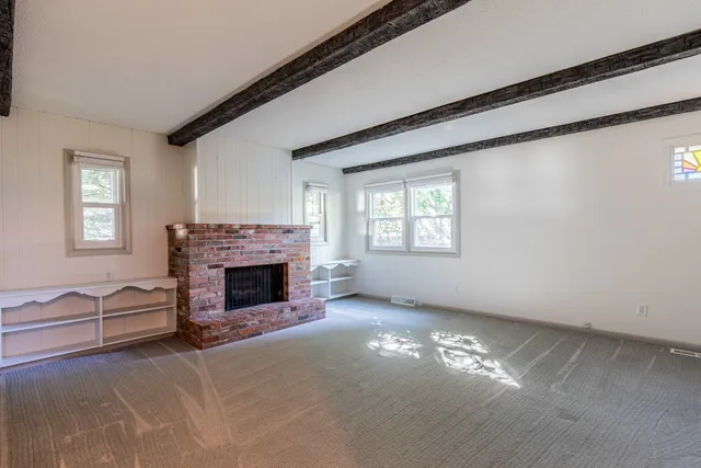 a view of a livingroom with a fireplace and window