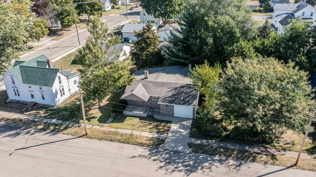 a view of a house with a yard and large tree