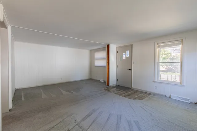 an empty room with windows and closet