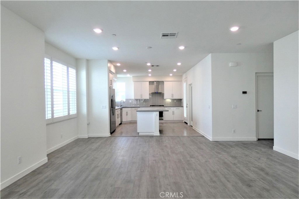 130 Acamar Irvine, CA 92618 - Photo 11 of 43 a view of kitchen with kitchen island granite countertop refrigerator oven sink and white cabinets with wooden floor