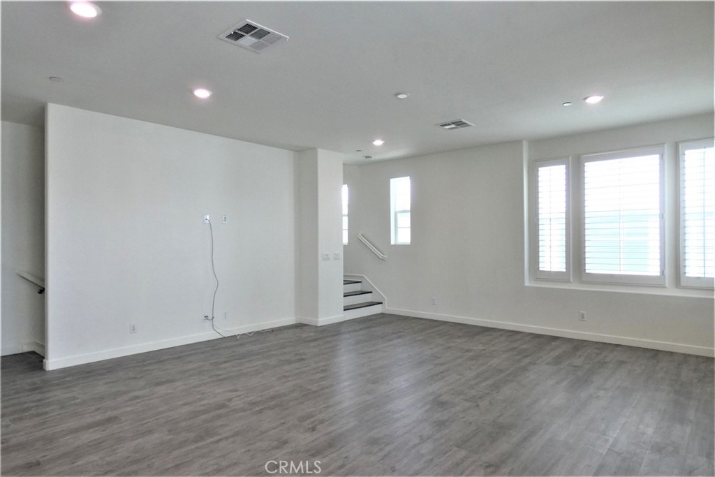 130 Acamar Irvine, CA 92618 - Photo 13 of 43 an empty room with wooden floor and windows