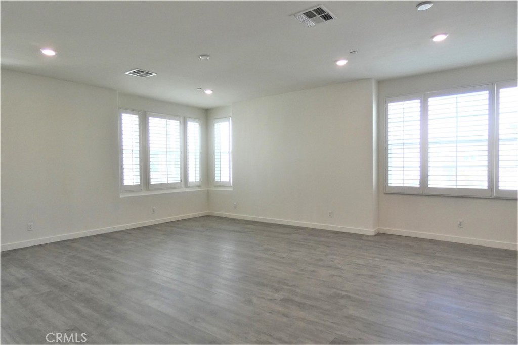 130 Acamar Irvine, CA 92618 - Photo 9 of 43 an empty room with wooden floor and windows