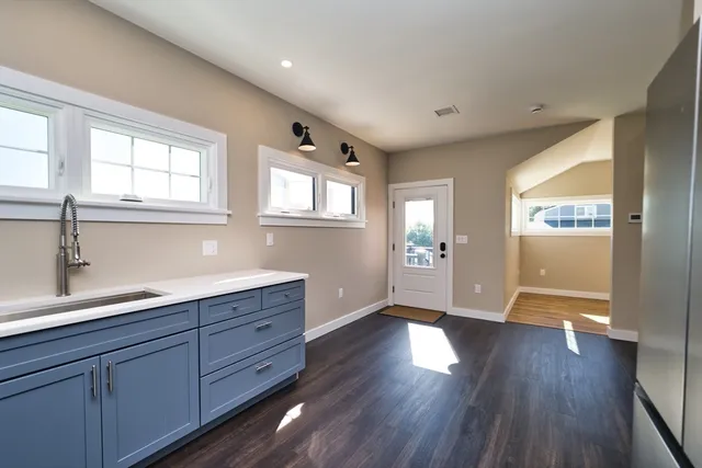a hallway with wooden floors and cabinet