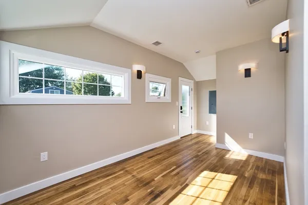 a view of a big room with wooden floor and windows