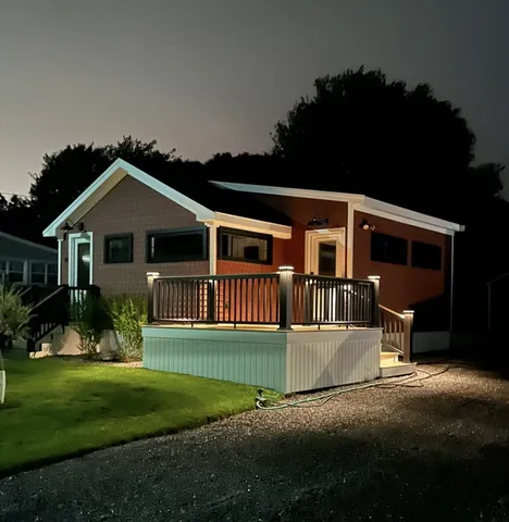 a front view of a house with a yard and trees