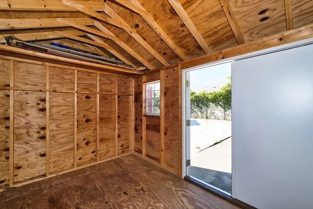 a view of empty room with wooden floor and windows