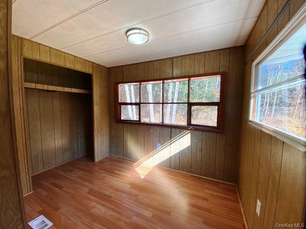141 Gale Road Mongaup Valley, NY 12762 - Photo 12 of 20 an empty room with wooden floor and windows