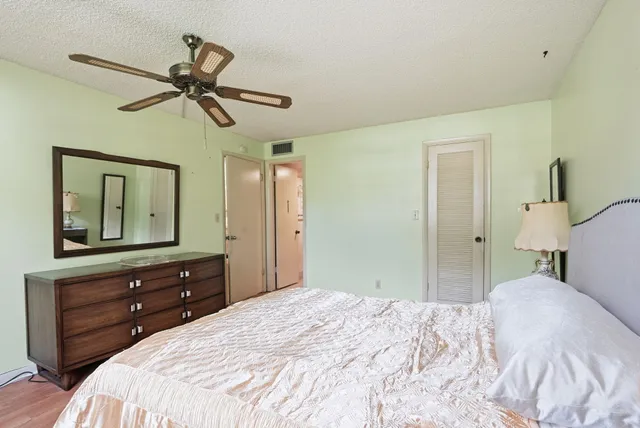 a bedroom with a bed and a mirror on the dresser