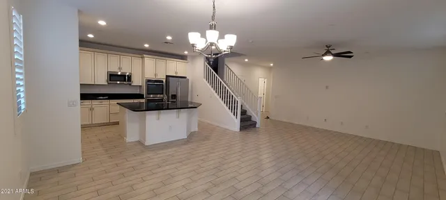 a living room with kitchen island furniture and a chandelier