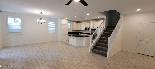 an empty room with wooden floor and staircase