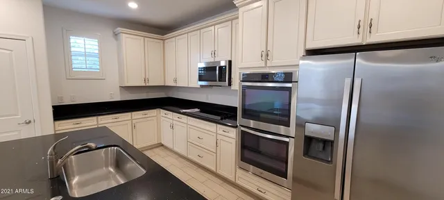 a kitchen with granite countertop white cabinets and stainless steel appliances