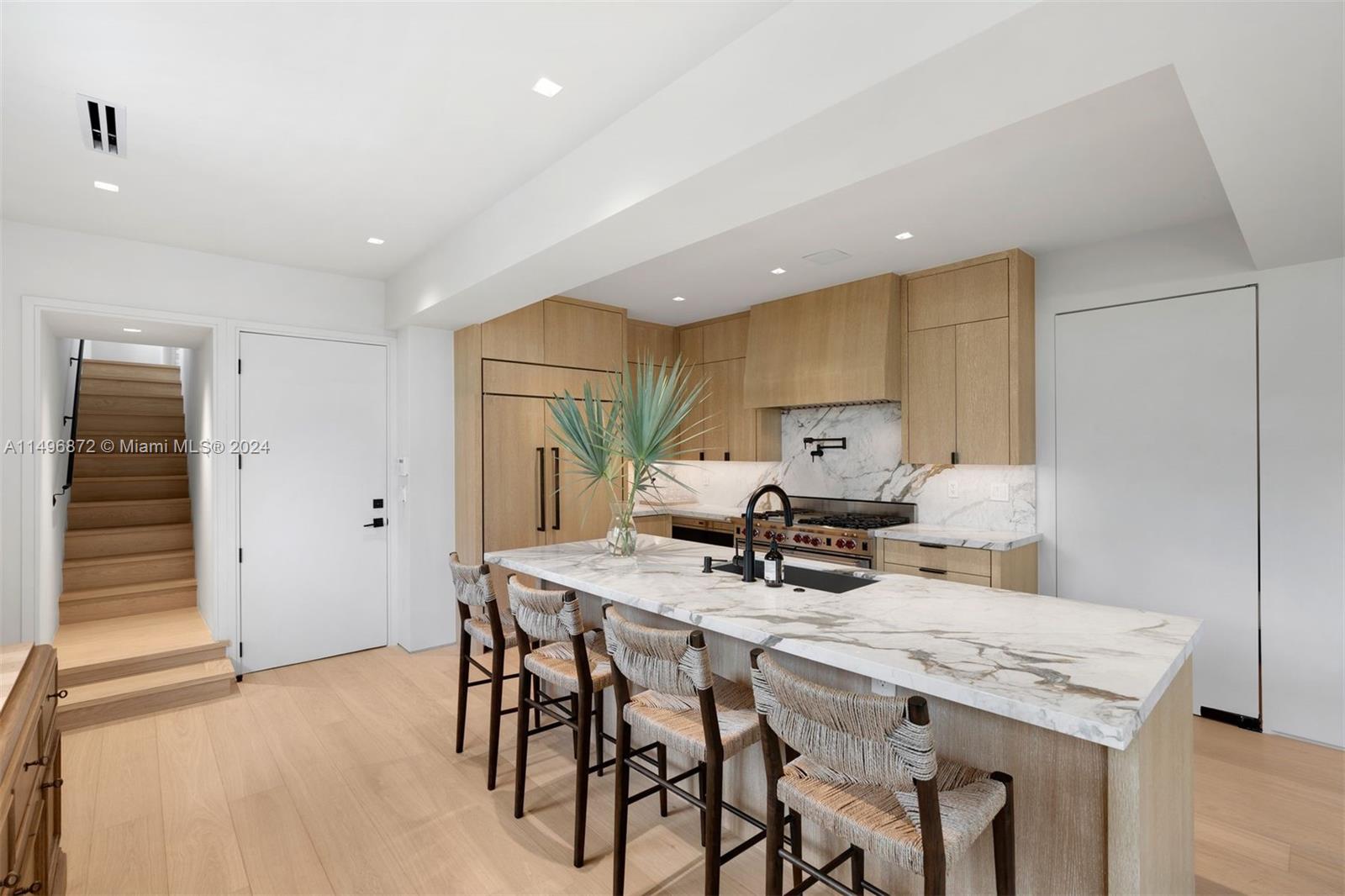 2770 Sunset Drive Miami Beach, FL 33140 - Photo 15 of 56 a kitchen with a table chairs and a refrigerator