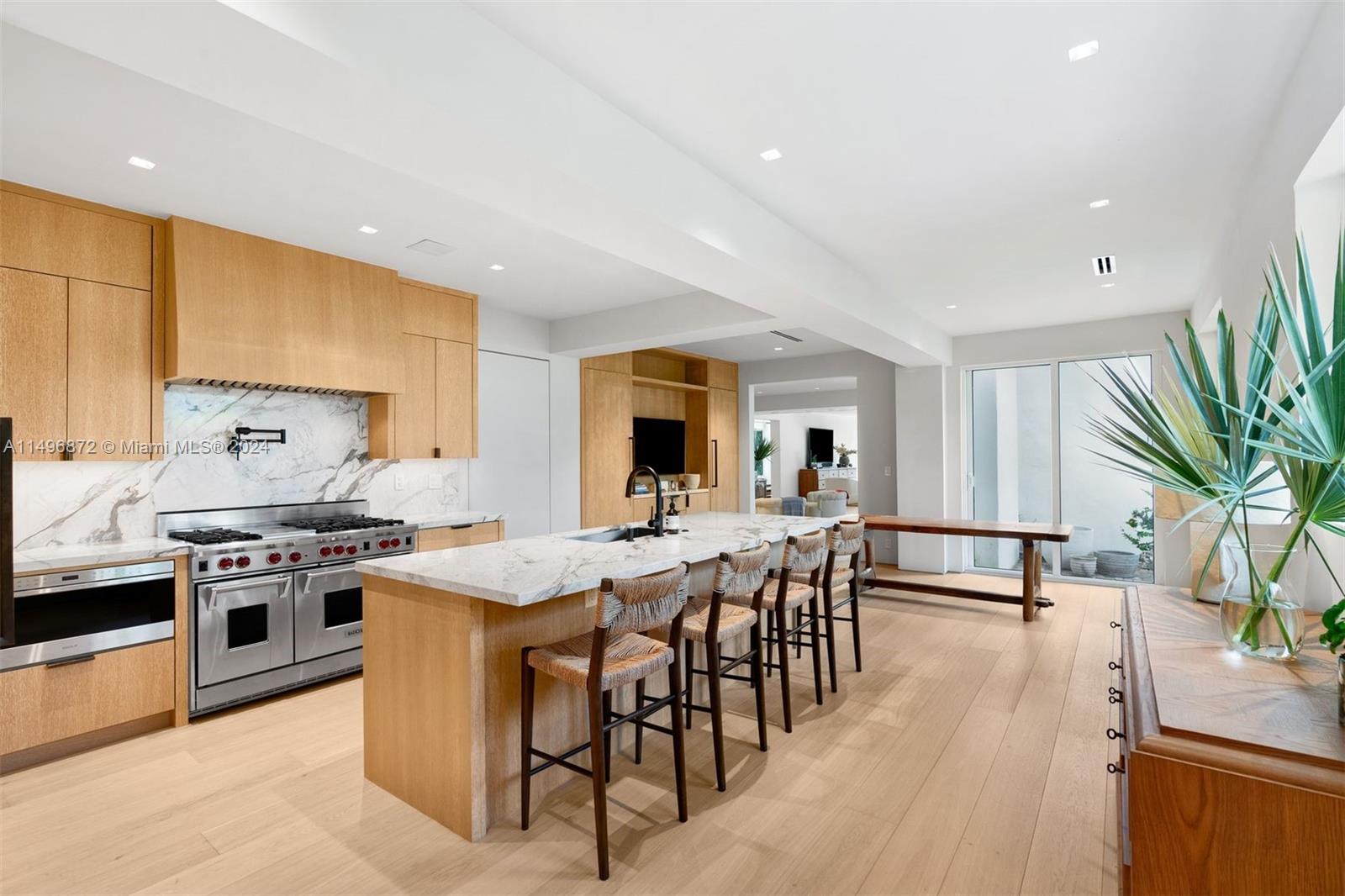 2770 Sunset Drive Miami Beach, FL 33140 - Photo 5 of 56 a dining hall with stainless steel appliances granite countertop a stove and a dining table with chairs