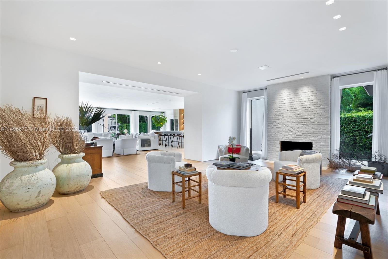 2770 Sunset Drive Miami Beach, FL 33140 - Photo 7 of 56 a living room with furniture a fireplace and a floor to ceiling window