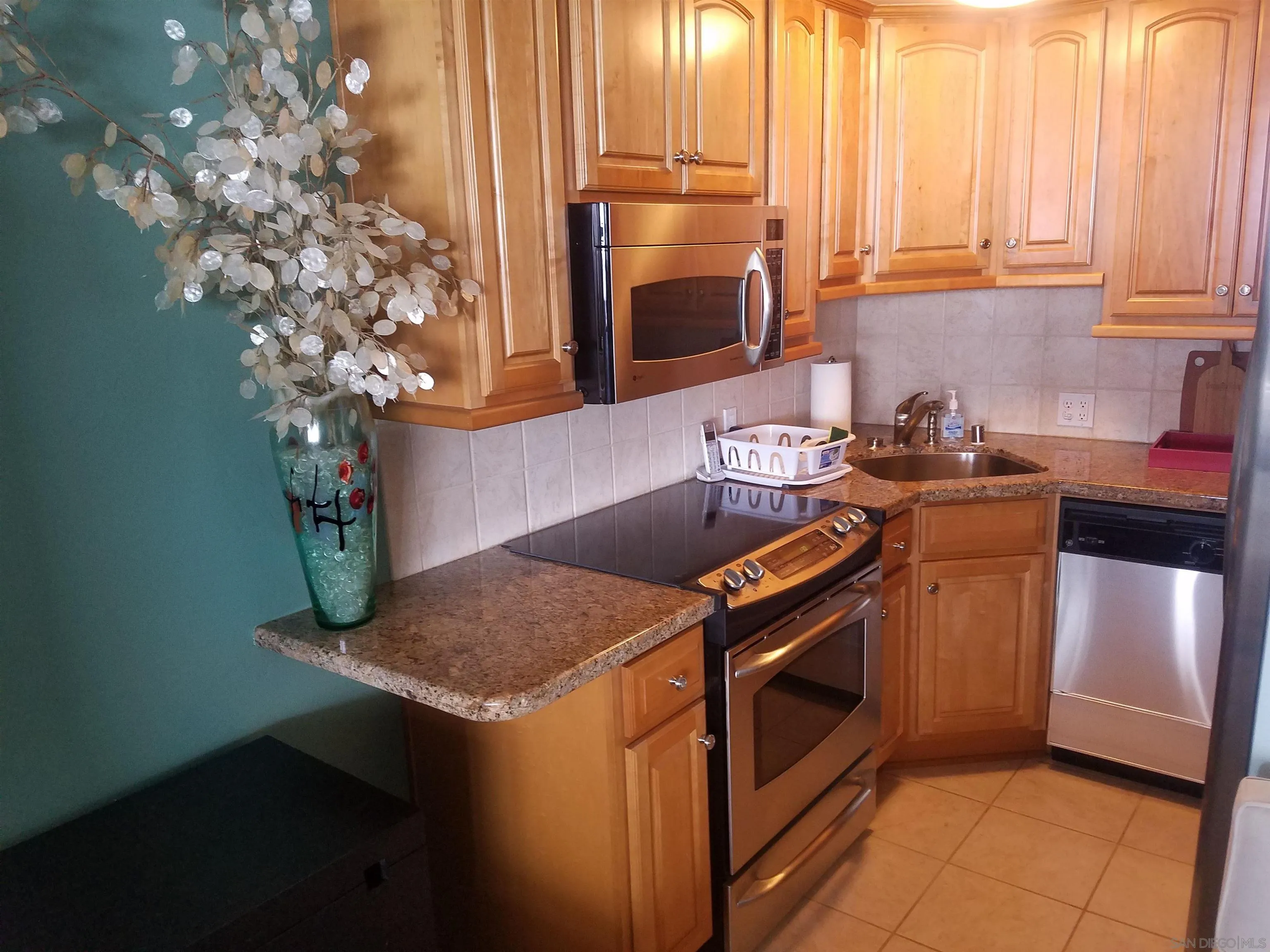 939 Coast Boulevard, Unit 3D La Jolla, CA 92037 - Photo 4 of 13 a kitchen with stainless steel appliances granite countertop a sink a stove and a microwave