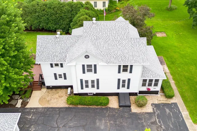 an aerial view of residential houses with outdoor space and trees