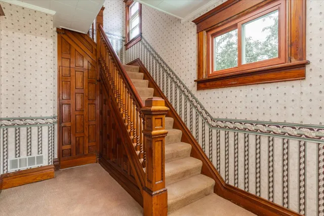 a view of staircase with railing and a window