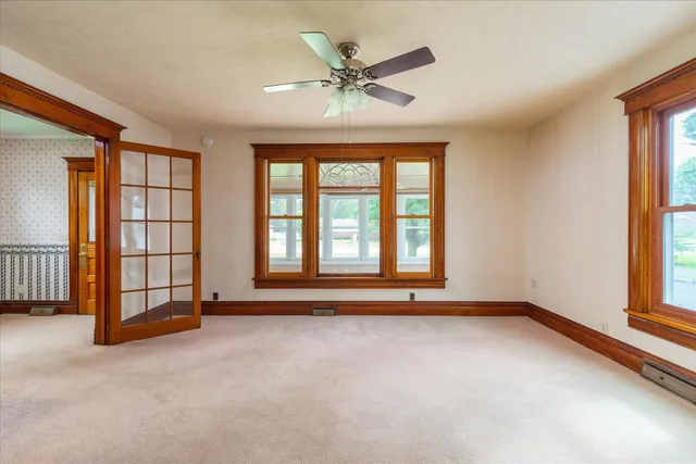 an empty room with ceiling fan and window