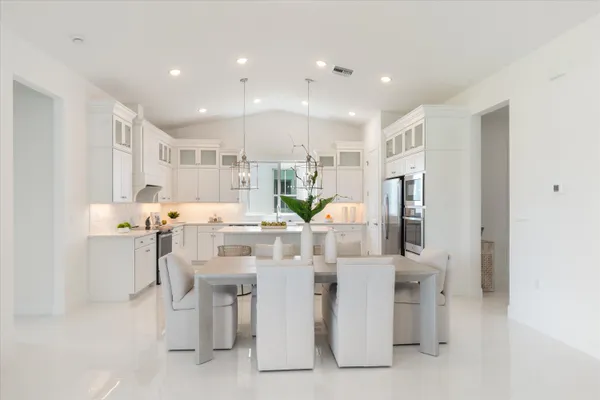 a kitchen that has a lot of cabinets in it and wooden floors