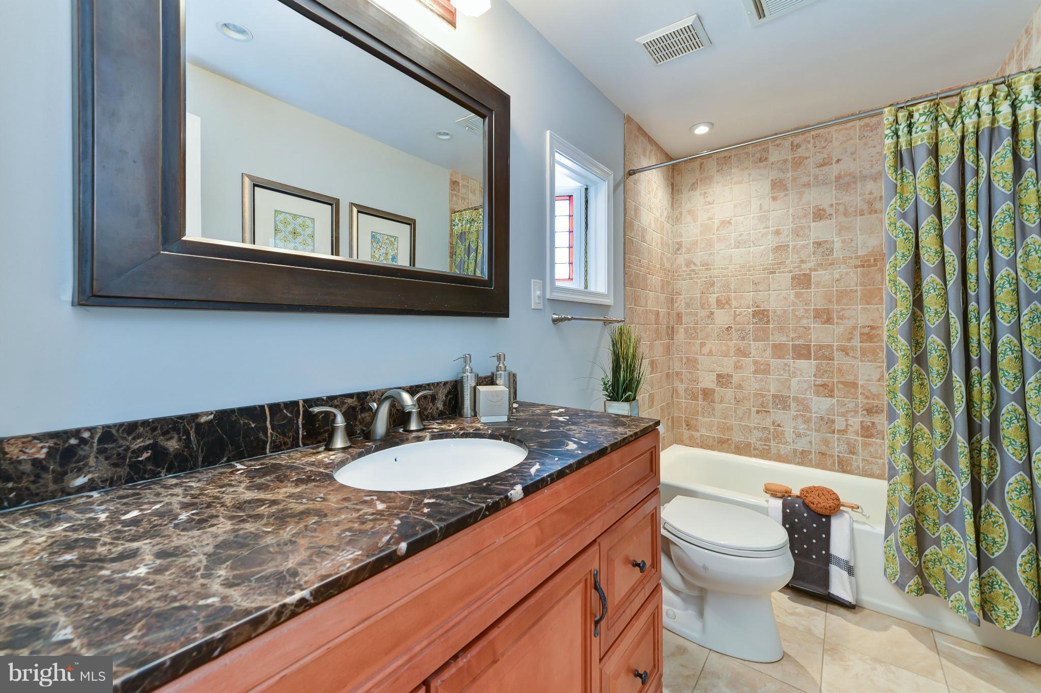 1243 Linden Place Northeast Washington, DC 20002 - Photo 19 of 30 a bathroom with a granite countertop sink mirror vanity and toilet