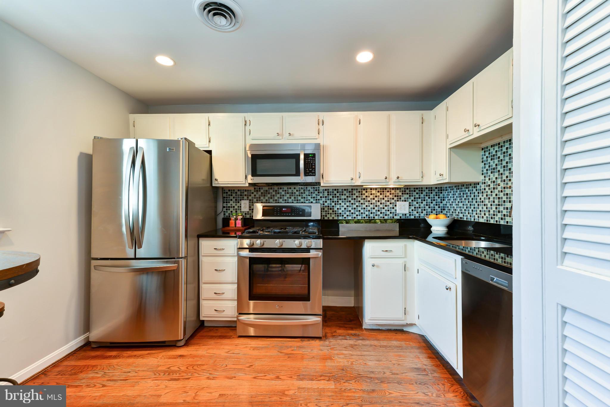 1243 Linden Place Northeast Washington, DC 20002 - Photo 10 of 30 a kitchen with granite countertop a refrigerator and a stove top oven